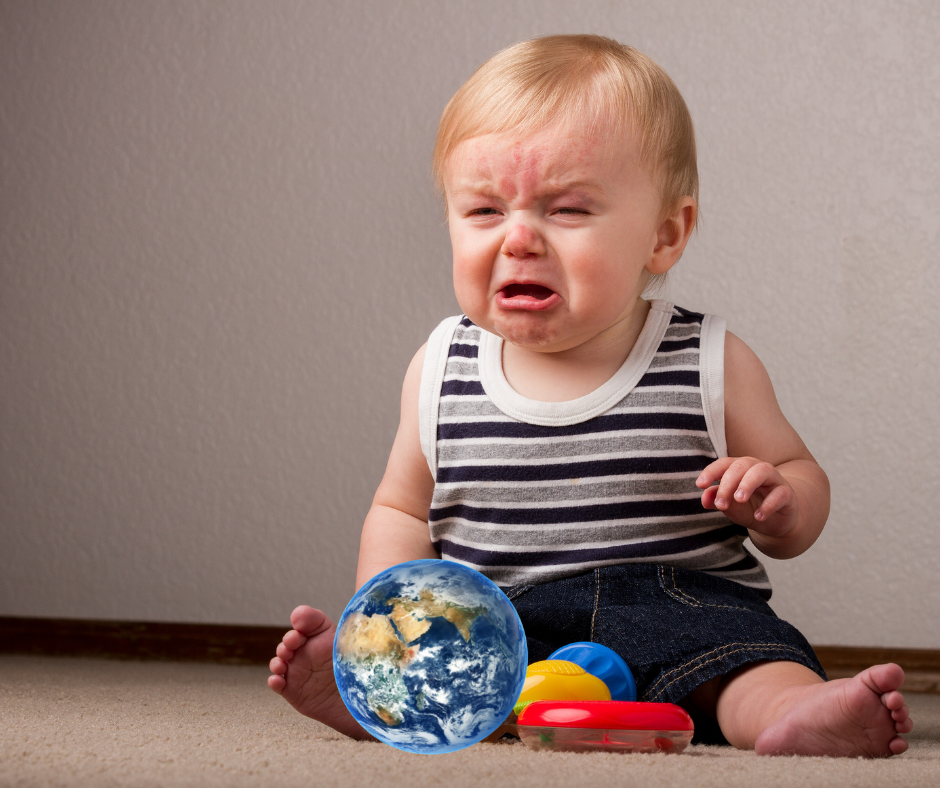 Een baby die huilt met een speelgoedplaneet aarde