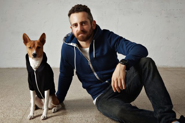 Man en hond met bijpassende sweatshirts